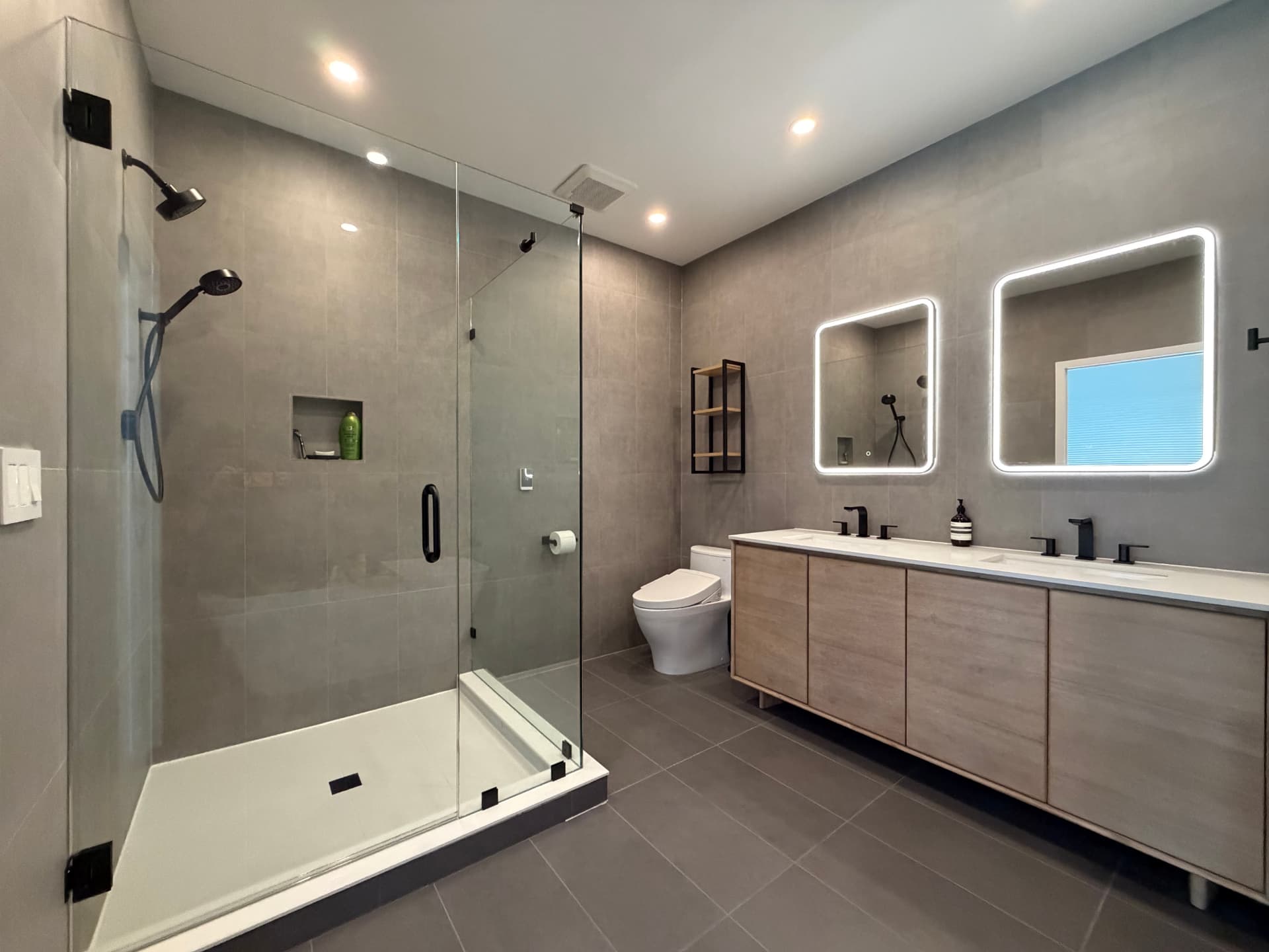 Remodeled modern bathroom with glass shower and floating vanity