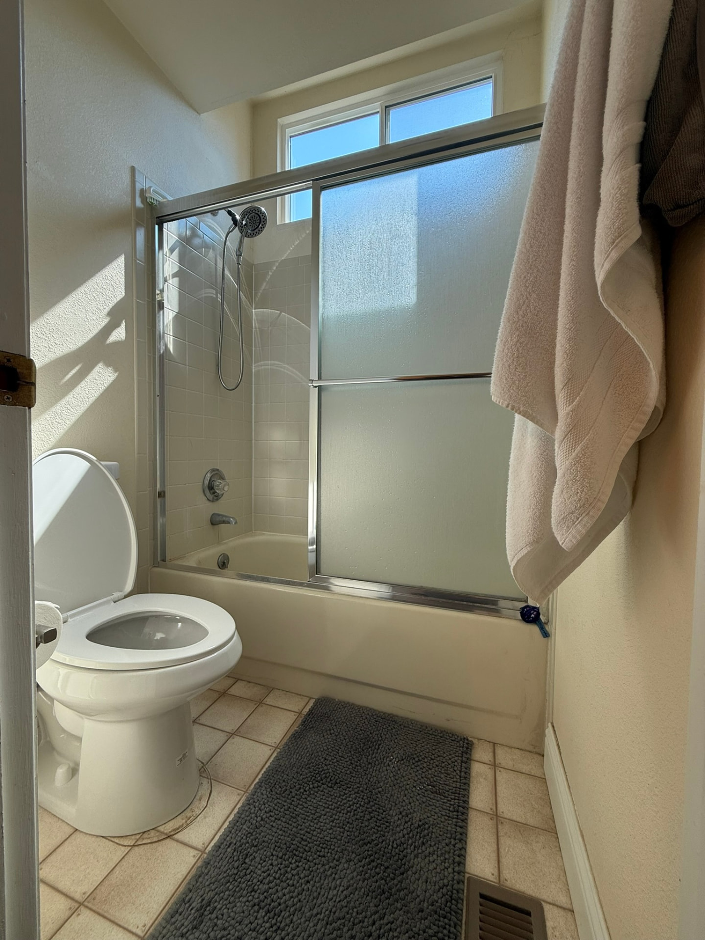 Original tub with framed sliding glass door and dated tile