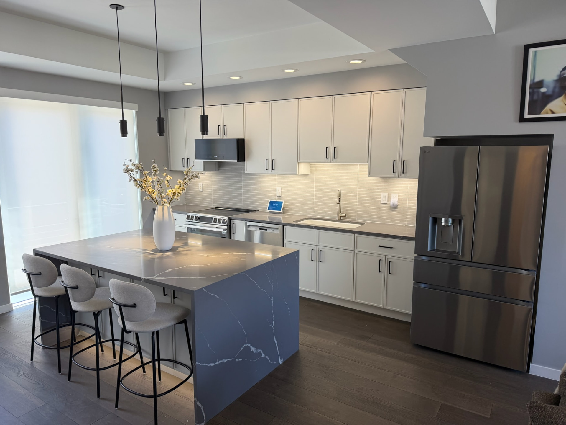 Modern kitchen with island, pendant lighting, and stainless appliances after Sinkovec Remodeling remodel